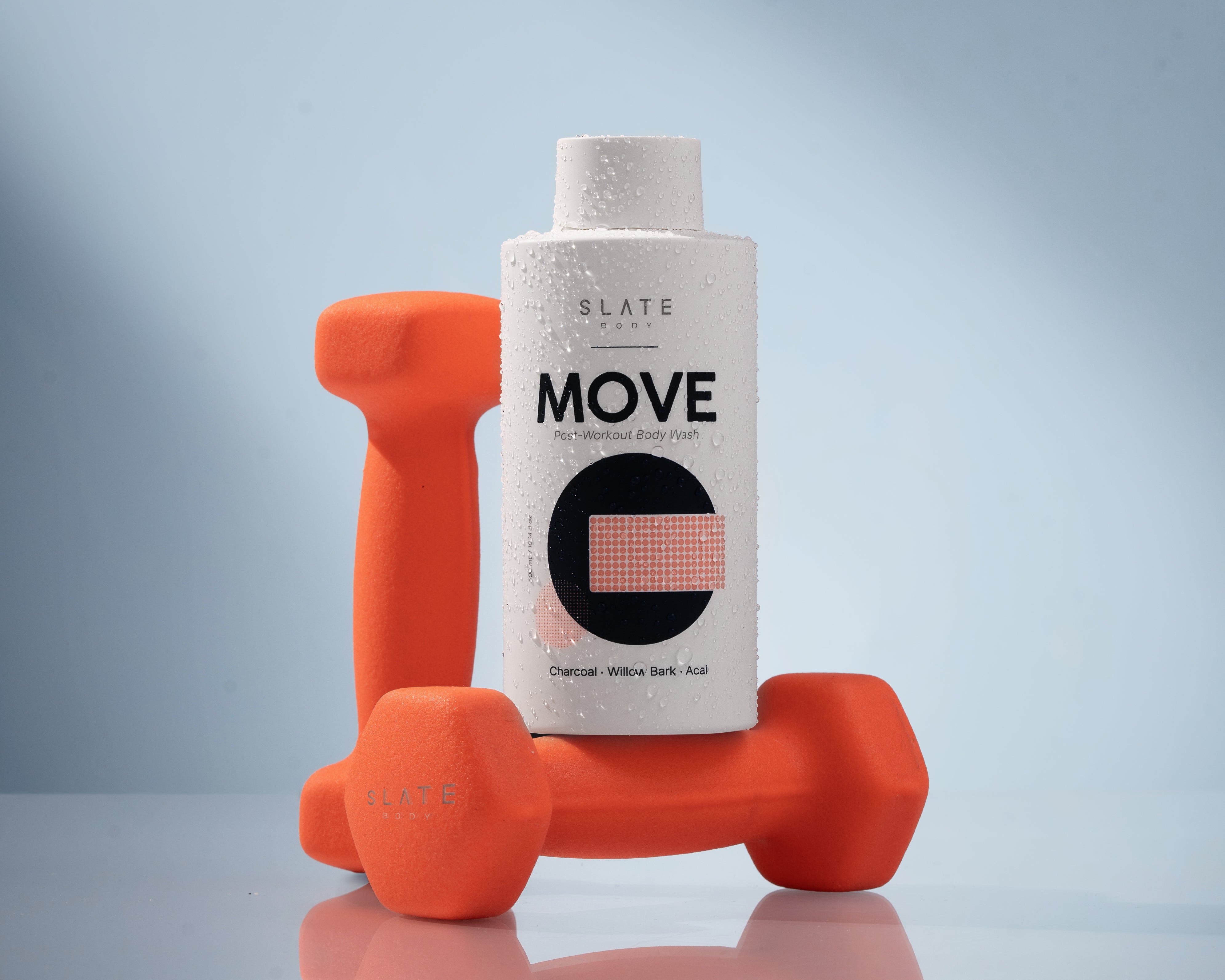 SLATE Body MOVE - post-workout body wash thar smells like citrus and sea salt. Pictured with orange dumbells