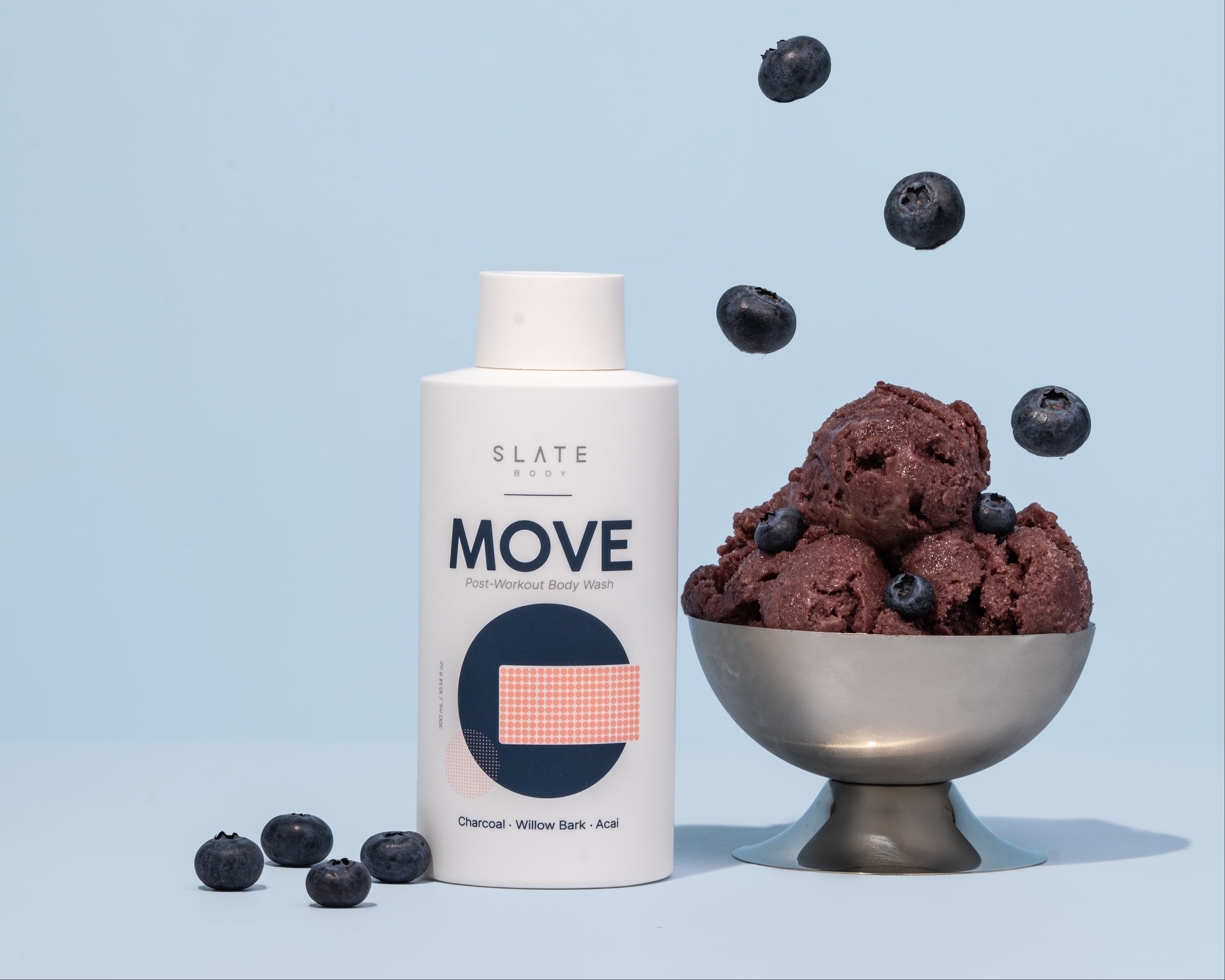 Bowl of Acai cream with blueberries and a bottle labeled 'Slate Body - MOVE' on a light blue background