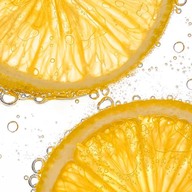 Fresh lemon slices in sparkling water, a natural source of Vitamin C for brightening the skin